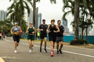 A group of diverse runners jogging along a scenic city pathway in Panama City, promoting healthy lifestyle.